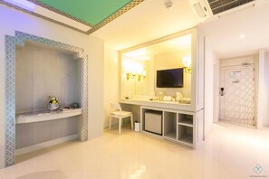 A modern bathroom with a vanity, a mirror, a television, and a door with a patterned design.