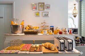 Un buffet de petit-déjeuner proposant une variété d’aliments, un coin pour les jus de fruits et un grille-pain.