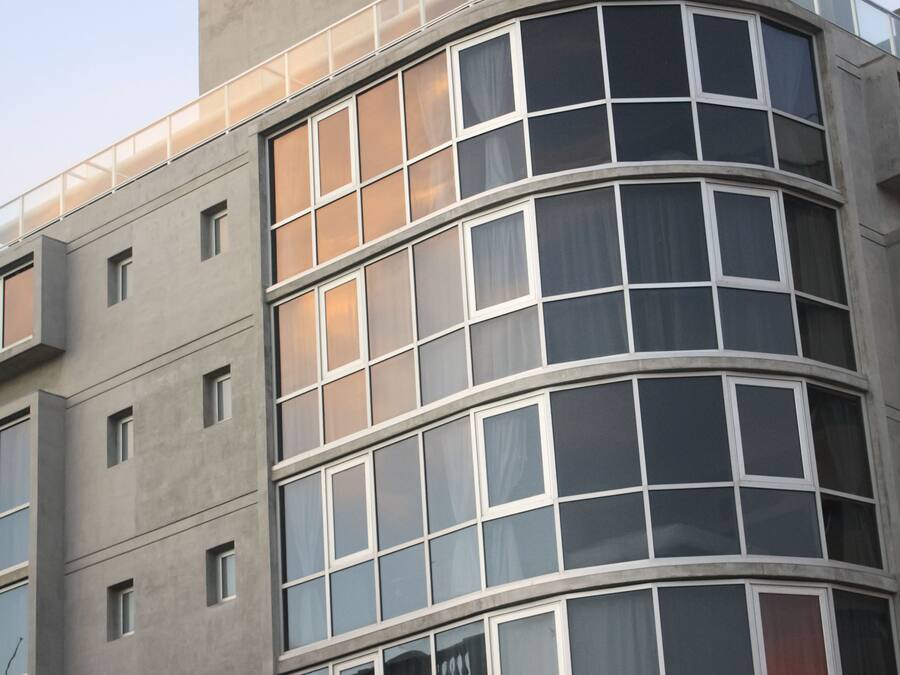 Un edificio moderno con fachada curva, ventanas amplias y un cartel llamativo que dice "SAS DESIGN HOTEL".