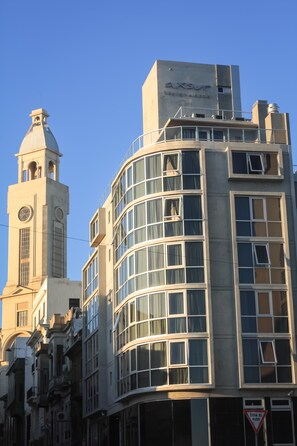 Un bâtiment moderne doté d’une tour horlogère et d’une enseigne sur laquelle on peut lire « AXSUR ».