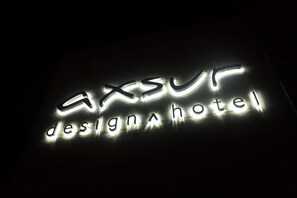 A sign for the AXSUR Design Hotel with illuminated lettering. - Axsur Design Hotel (Montevideo)