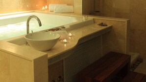 Ein modernes Badezimmer mit einer großzügigen Badewanne, einem Waschbecken und einer Dusche.