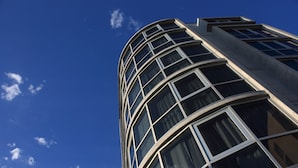 Ein hohes Gebäude mit einer geschwungenen Fassade und zahlreichen Fenstern.