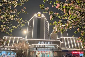 A building with illuminated signage and a prominent entrance. - Yucheng Hotel (Suzhou)