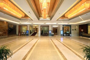 A spacious lobby with a marble floor, a reception desk, a staircase, and a large chandelier. - Yucheng Hotel (Suzhou)