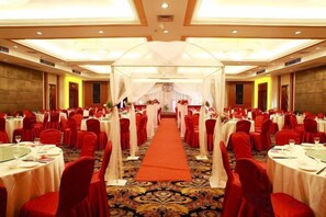 A banquet hall with round tables, red chairs, and a central aisle. - Yucheng Hotel (Suzhou)