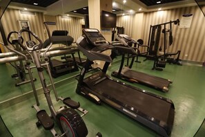 A gym with various exercise equipment including treadmills, stationary bikes, and weight machines. - Yucheng Hotel (Suzhou)