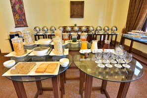 A breakfast buffet with various food items and beverages, arranged on glass tables. - Swat Serena Hotel (Swat)