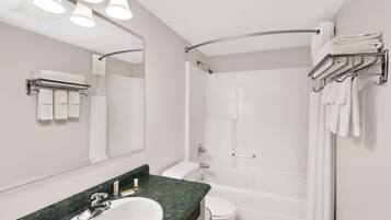 Un baño moderno con lavamanos, espejo y zona de ducha.