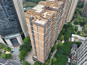 A high-rise building with multiple balconies and a rooftop garden. - Dan Executive Apartment Guangzhou (Guangzhou)