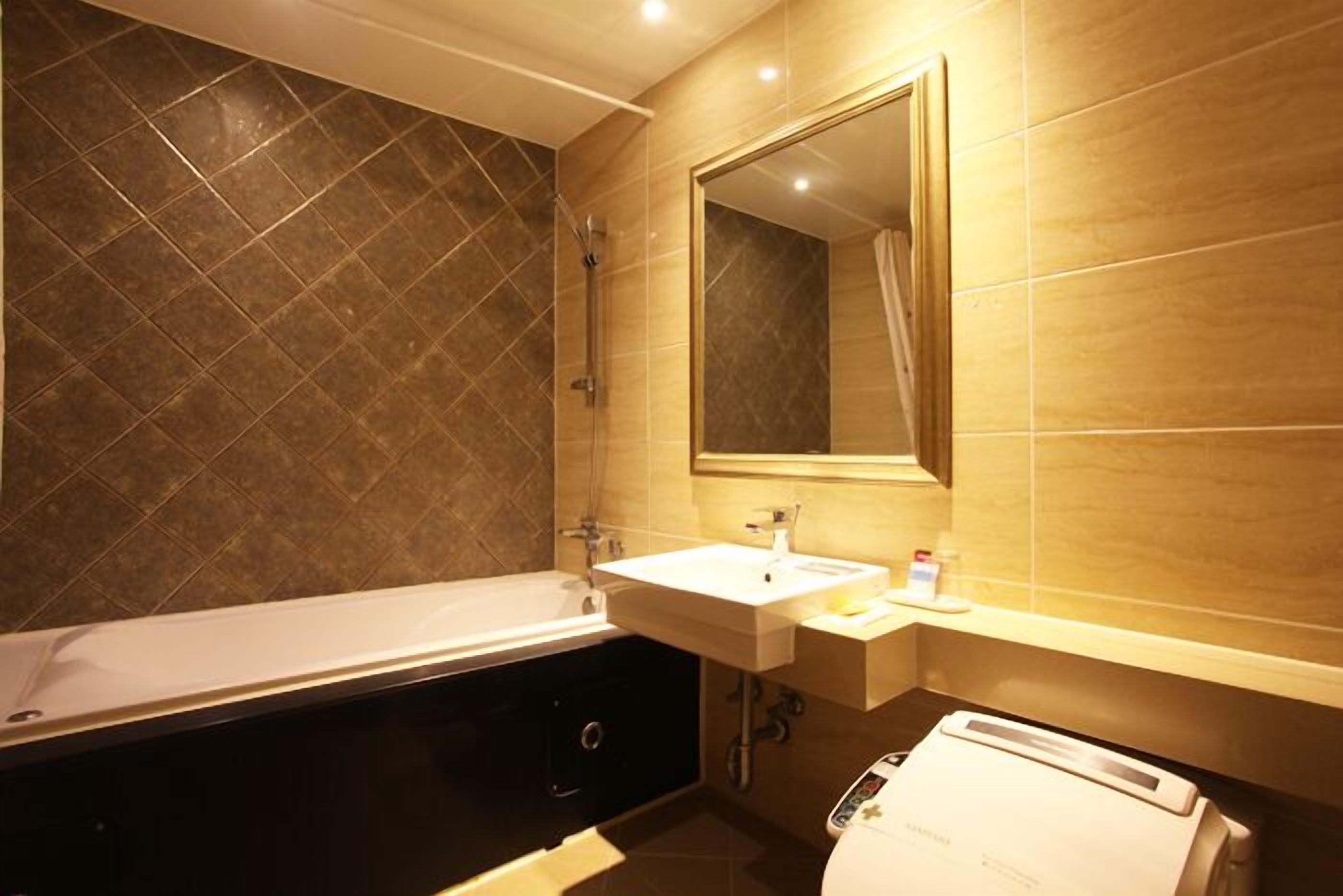 Une salle de bain moderne avec une baignoire, un lavabo et un miroir.