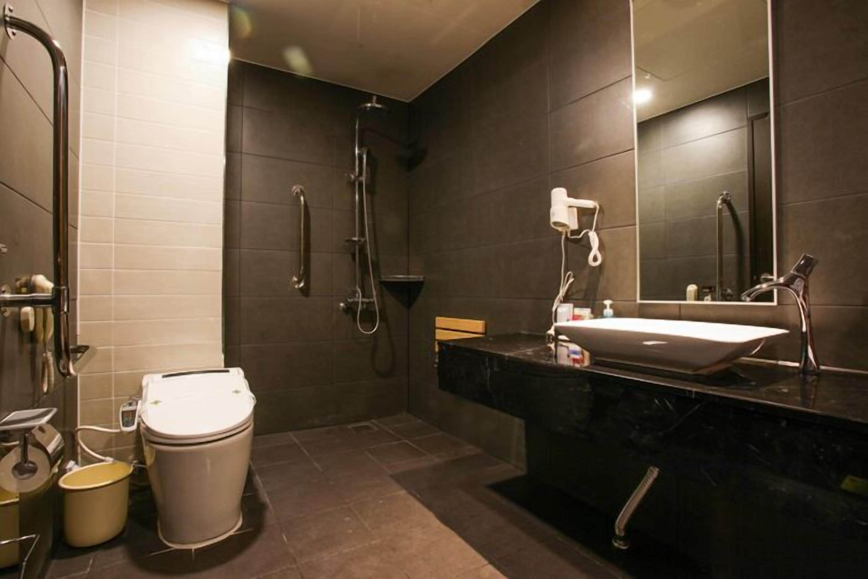 Un baño moderno con inodoro, bidé y ducha.