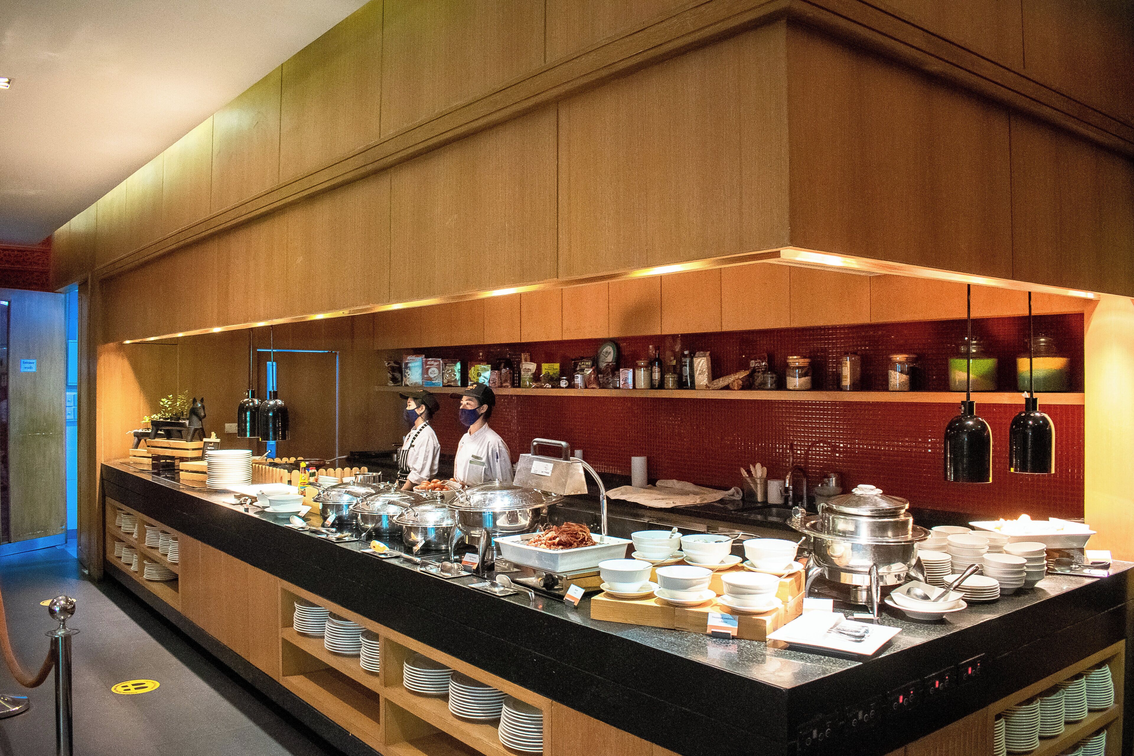 A buffet setup with various food items and serving utensils.