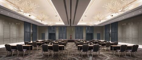 A conference room with a long table, multiple chairs, and a patterned carpet.