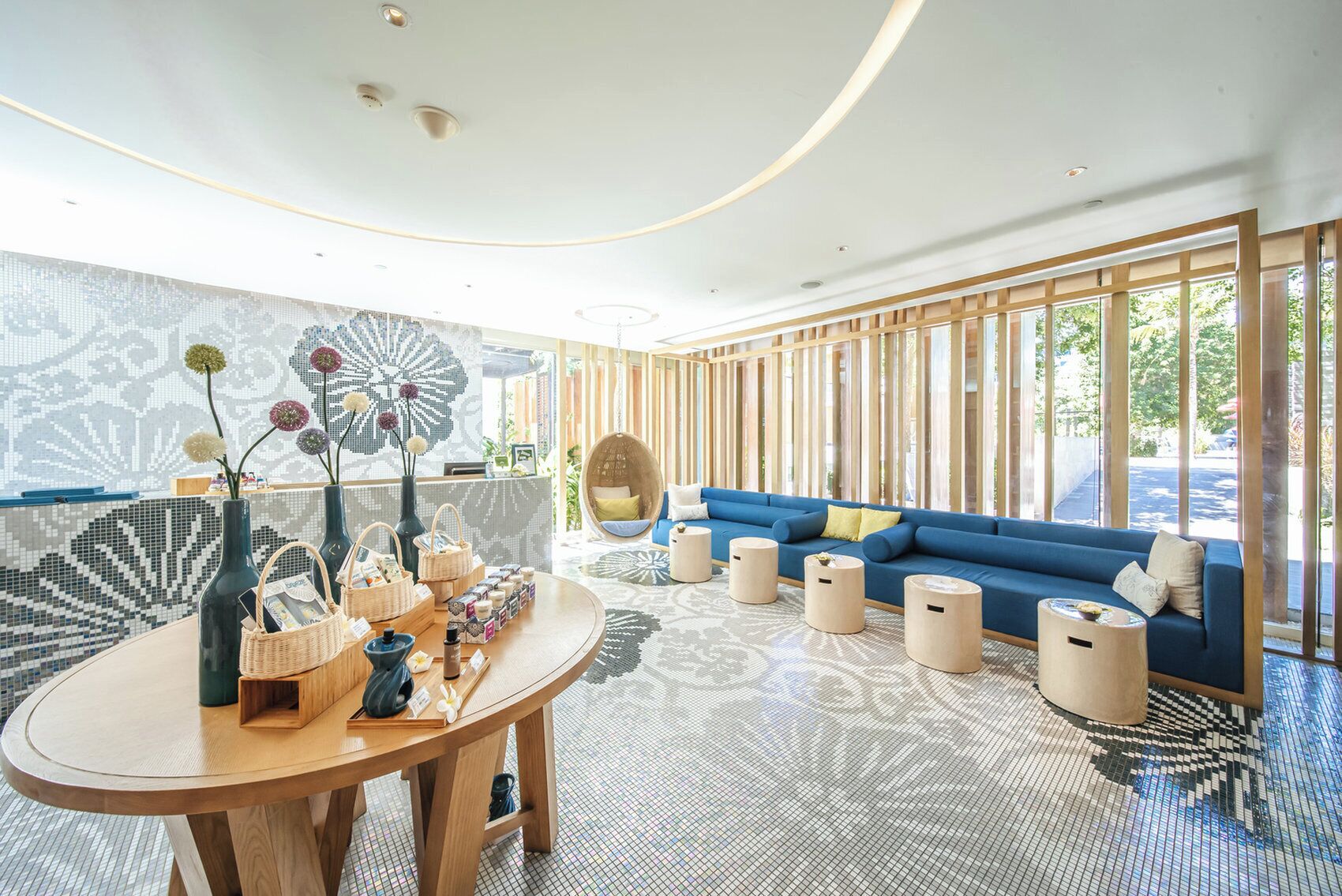 A modern interior with a blue sofa, wooden accents, and a patterned floor.