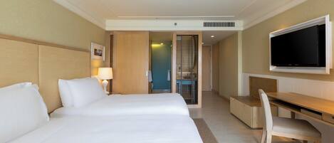 Una habitación de hotel con una cama grande, un escritorio, una silla y un televisor.