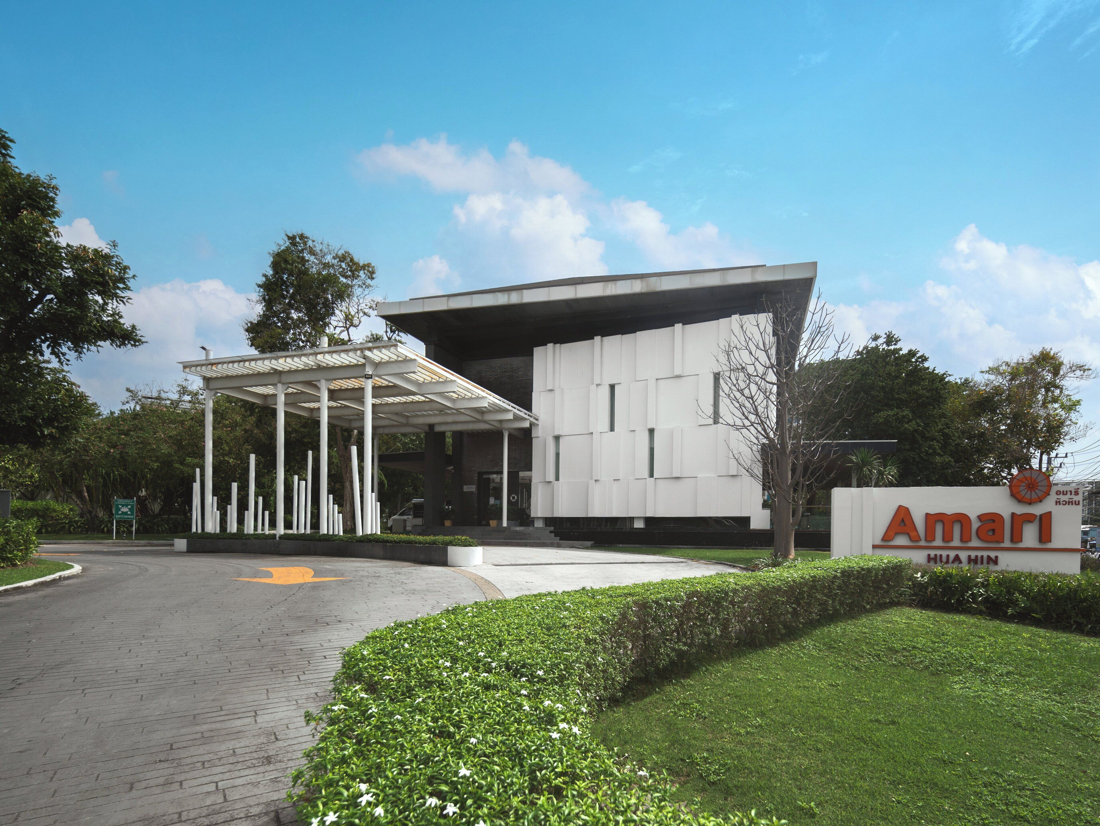 A modern building with a covered entrance and a sign reading "Amari Hua Hin".