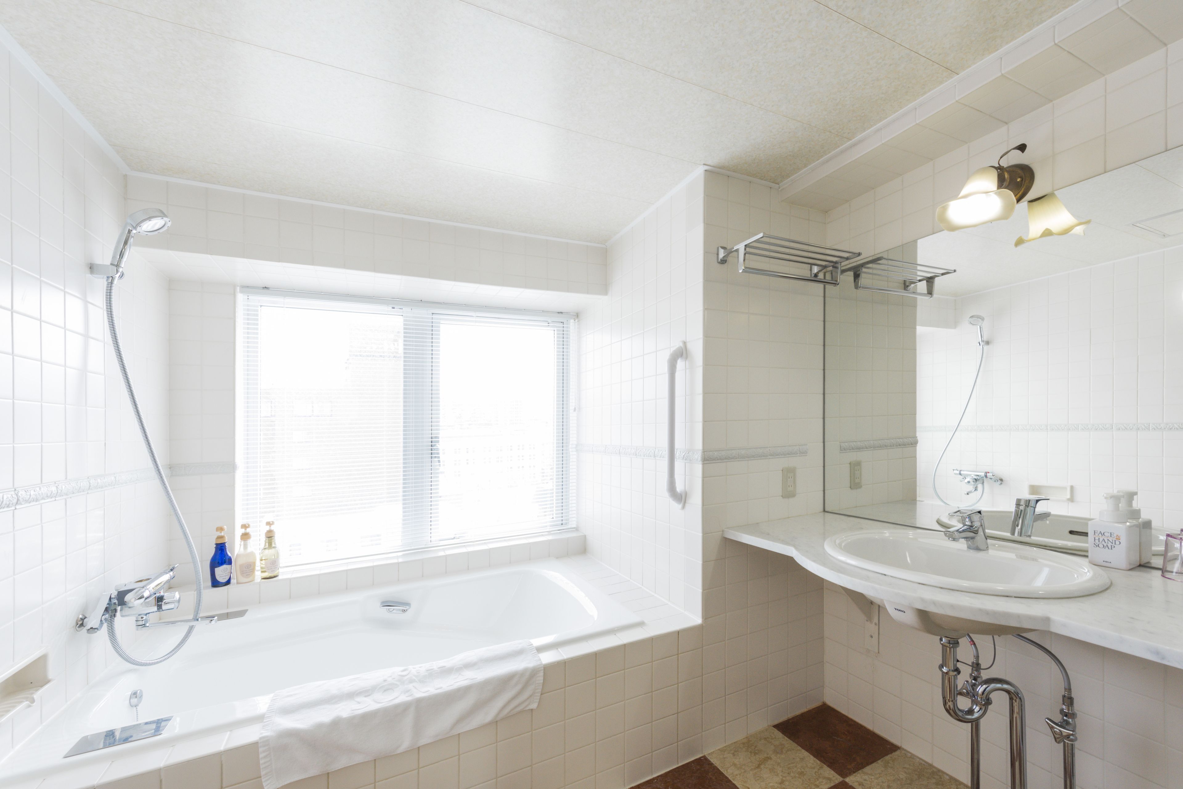 A modern bathroom with a bathtub, a sink, and a large mirror.
