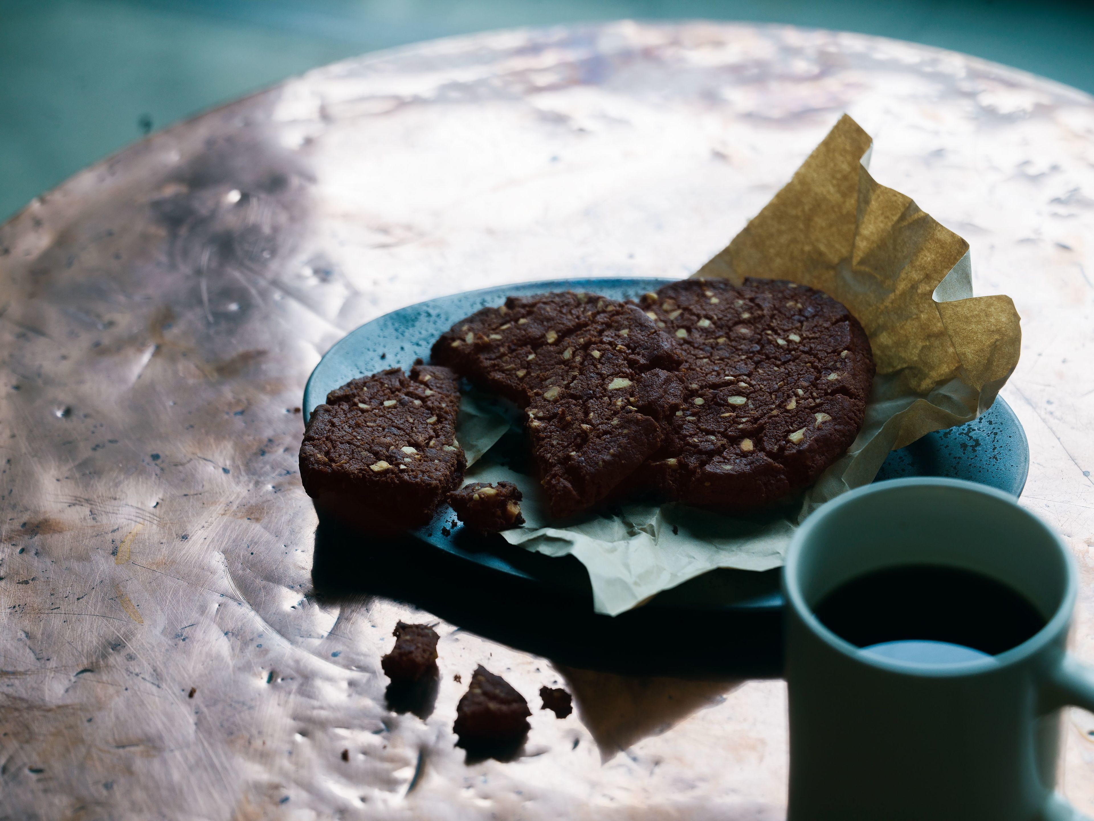 A plate with cookies and a cup of coffee on a table.