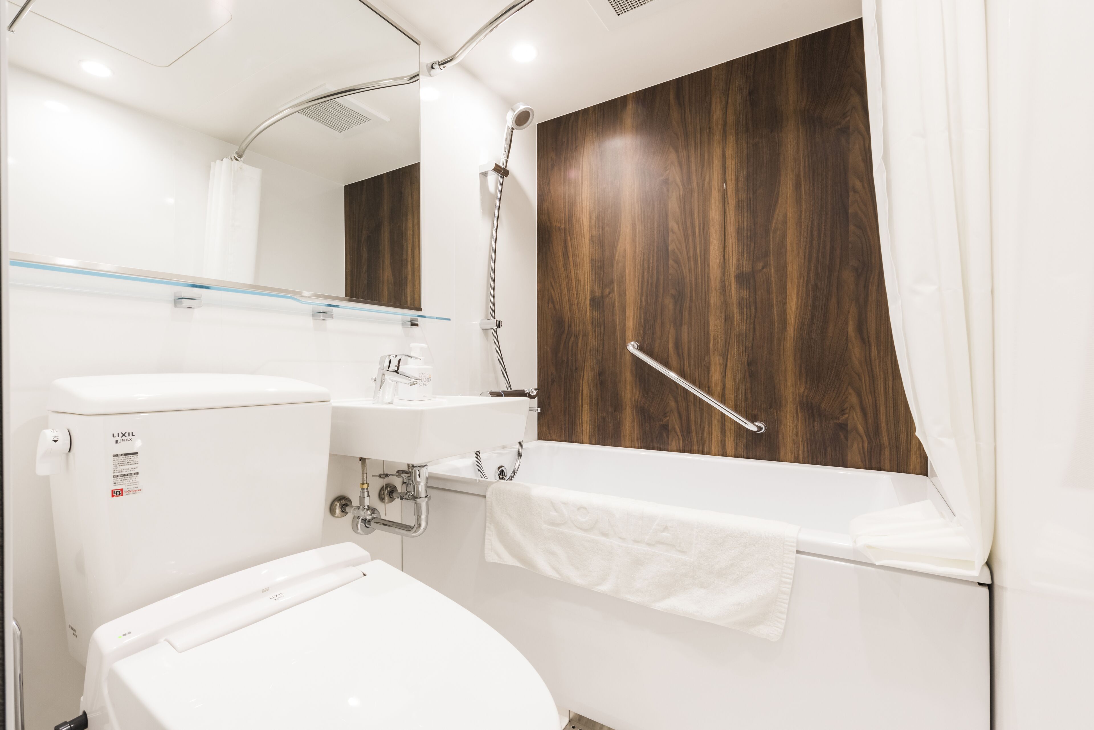 A modern bathroom with a toilet, sink, and shower.