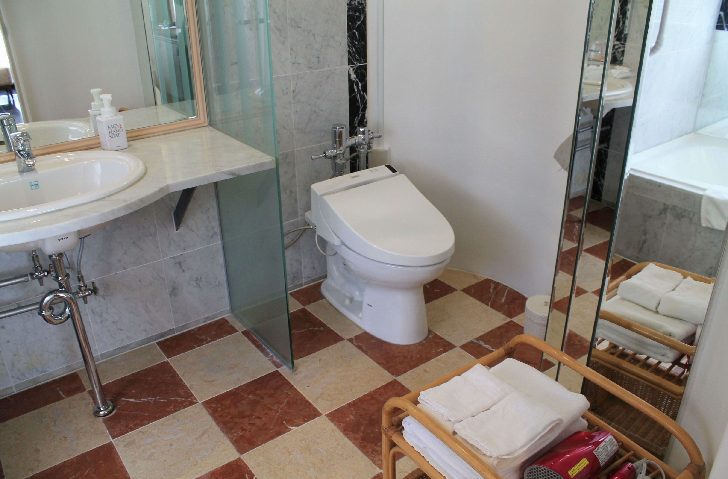 A bathroom with a sink, toilet, and glass shower enclosure.
