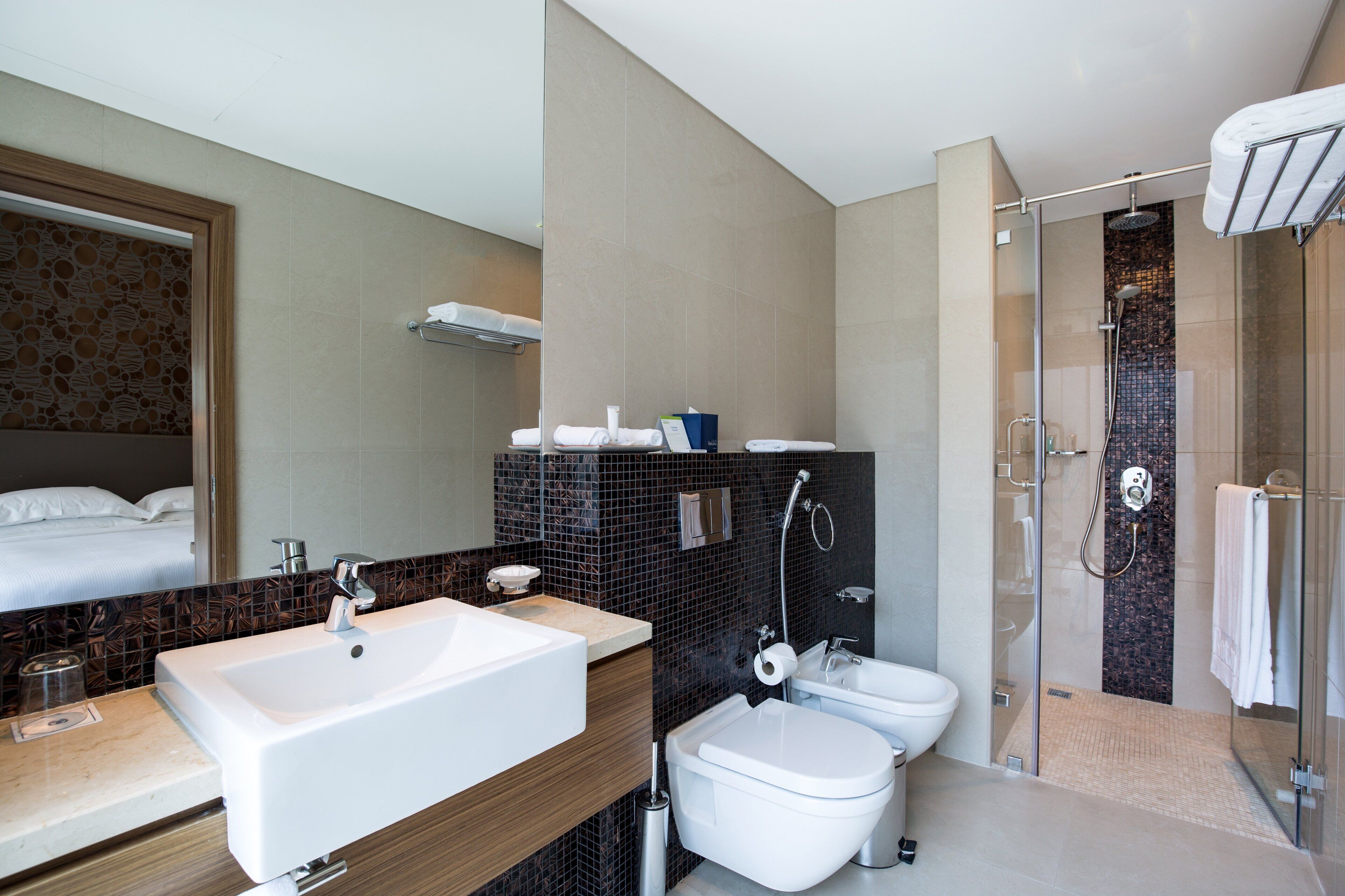 A modern bathroom with a large sink, toilet, and shower area.
