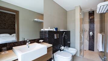A modern bathroom with a large sink, toilet, and shower area.