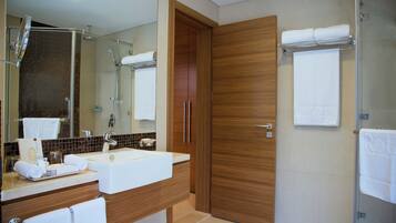 A modern bathroom with a sink, mirror, and wooden door.