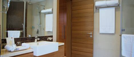 A modern bathroom with a sink, mirror, and wooden door.