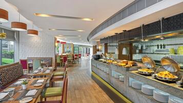 Un espace buffet proposant une variété de plats et un coin repas avec des tables et des chaises.