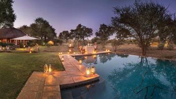 Een buitenzwembad, parasols voor strand/zwembad