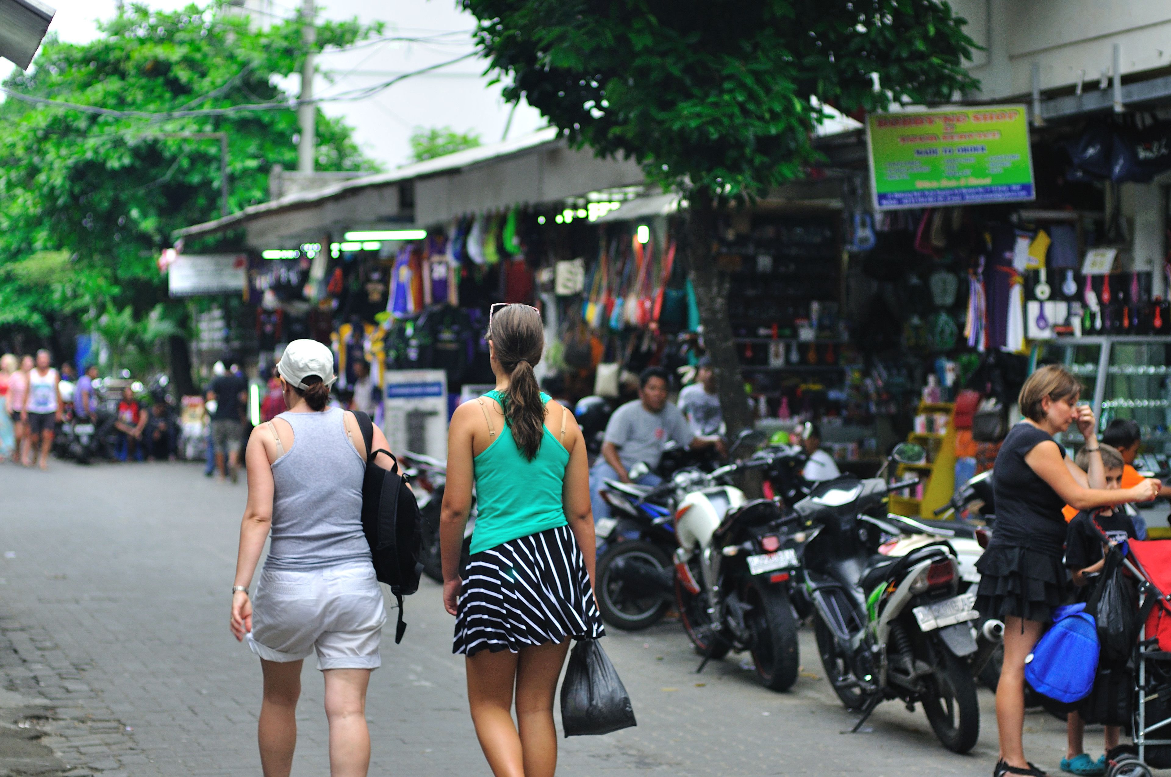 A busy street with pedestrians and parked motorcycles.