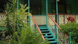 Ein zweistöckiges Haus mit Veranda und Treppe.