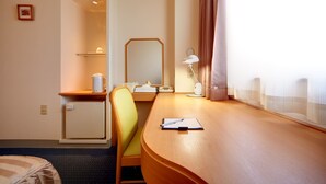 A hotel room with a desk, chair, and a small refrigerator. - Roco Inn Matsuyama (Naha)