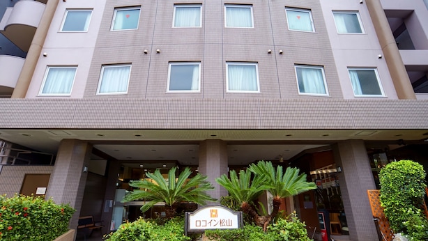 A multi-story hotel with a tiled facade, multiple balconies, and a sign indicating it is the "Rokin Matsushima." - Roco Inn Matsuyama (Naha)