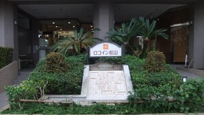 A hotel entrance with a sign reading "Okoyama Matsumoto". - Roco Inn Matsuyama (Naha)