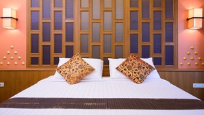 A hotel room with a large bed, two decorative pillows, a wooden headboard, and wall sconces. -  Golden House BTS Chidlom Bangkok (Bangkok)