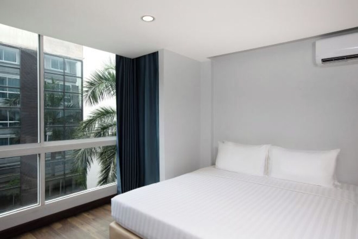 Une chambre d’hôtel moderne dotée d’une grande fenêtre, d’un lit et d’un appareil de climatisation.