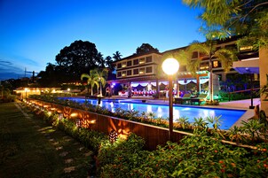 Una piscina al aire libre, sillones reclinables de piscina