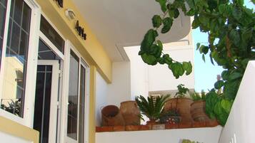 A building with a sign reading 'Diamond Ct.' and a balcony with potted plants.