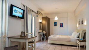 A hotel room with a bed, a desk, a chair, a television, and a bathroom. - Diamond Apts and Suites (Hersonissos)