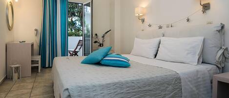 A bedroom with a bed, a nightstand, a lamp, a mirror, and a window with curtains.