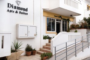 A building with a sign reading 'Diamond Apts & Suites' and a staircase leading to the entrance. - Diamond Apts and Suites (Hersonissos)