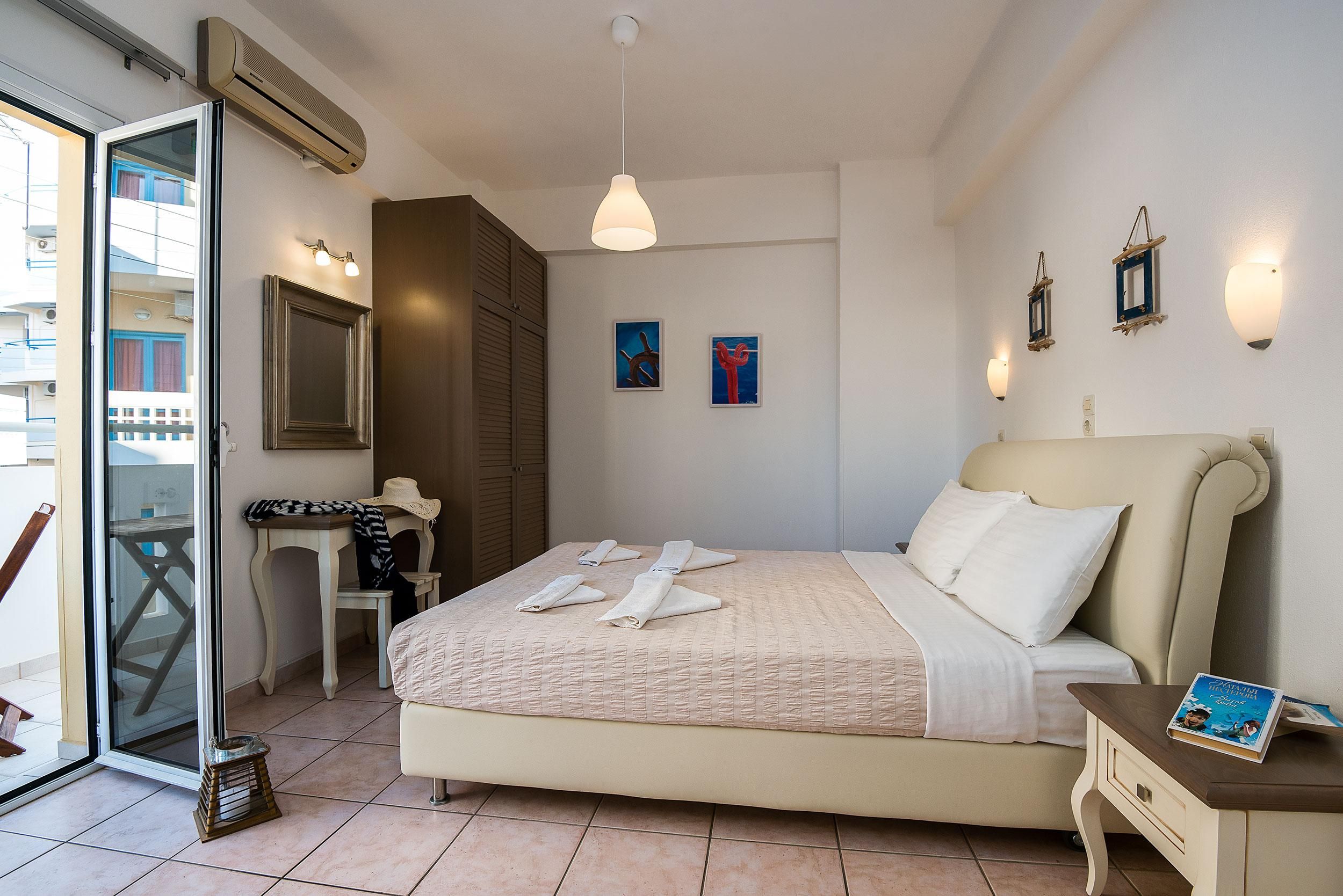 Ein Hotelzimmer mit einem Bett, Schreibtisch, Stuhl, Fenster und Tür.