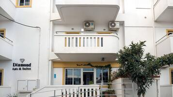 A building with a sign for 'Diamond Apts & Suites' and a staircase leading to the entrance.