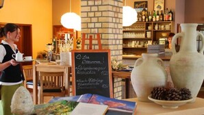 Een café interieur met een krijtbordmenu, houten meubels en decoratieve vazen.