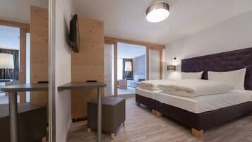 A modern hotel room with a bed, a desk, and a chair.