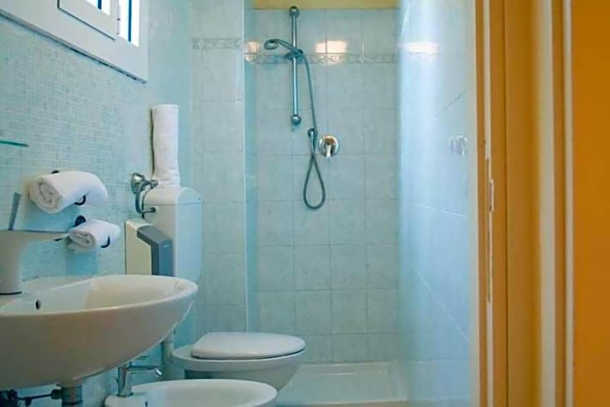 A bathroom with a shower, toilet, and sink.