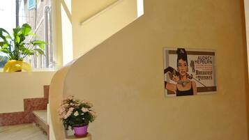 Eine Treppe mit einem Blumentopf und einem Plakat, das Audrey Hepburns Frühstück bei Tiffany anpreist.