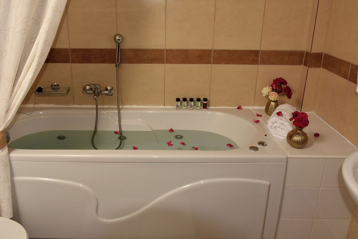 A bathroom with a bathtub, shower, and sink.